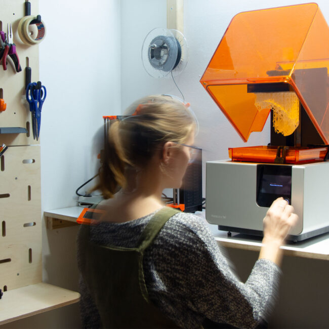 SLA 3D Drucker mit Person im Vordergrund und Modularerem Wandsystem
